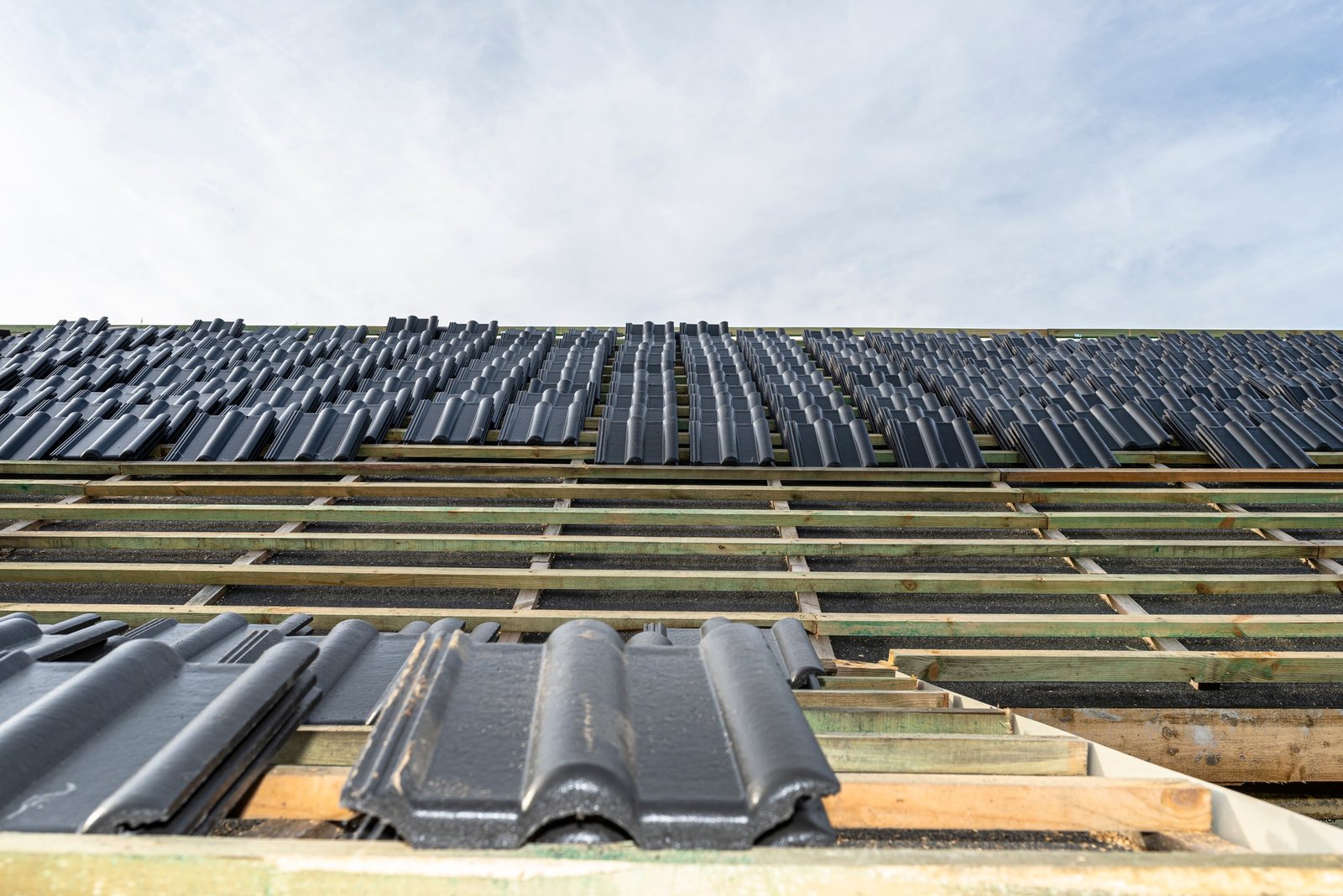Roof ceramic tile arranged in packets on the roof on roof battens. laying tiles on a boarded roof.